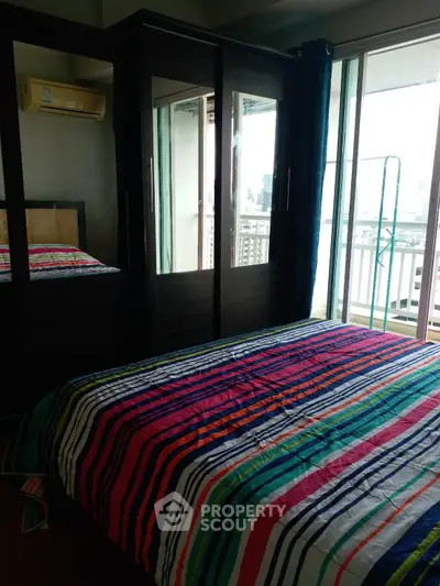 Cozy bedroom with colorful striped bedding and balcony view