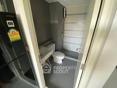 Modern bathroom with sleek fixtures and a compact design, featuring a shower and toilet.