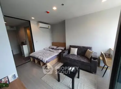 Modern studio apartment with cozy bed and stylish sofa in open layout.