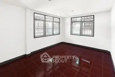 Spacious empty room with glossy red tiles and large windows