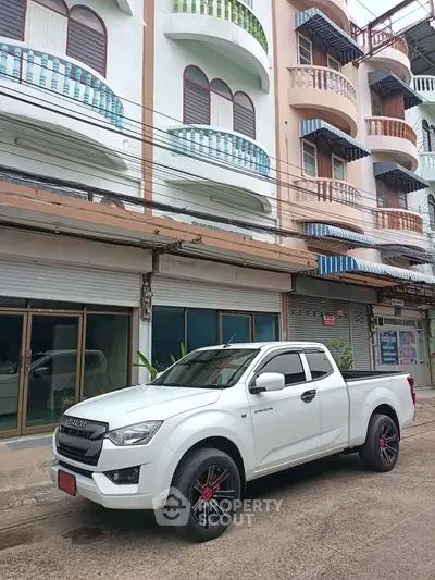 Charming multi-story building with unique balconies and street view, perfect for urban living.