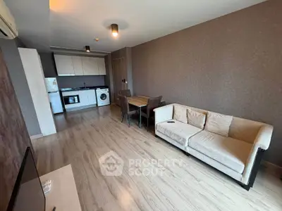 Modern living room with open kitchen, featuring cozy sofa and dining area, perfect for urban living.