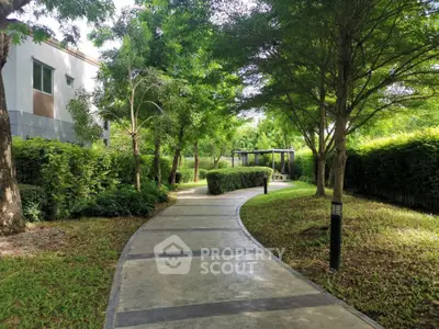 Serene garden pathway with lush greenery and modern architecture, perfect for relaxation.