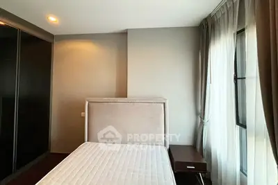 Modern bedroom with large window and stylish headboard in a cozy apartment.