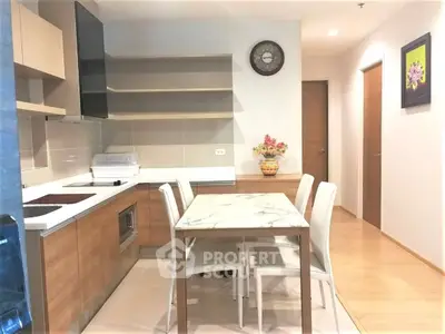 Modern kitchen with sleek cabinetry and dining area in a stylish apartment.