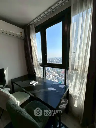Cozy study area with stunning city view from high-rise apartment window.