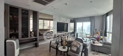 Luxurious living room with modern decor and city view, featuring a large TV and elegant furnishings.