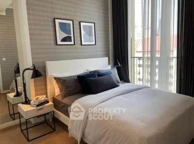 Modern bedroom with stylish decor and large windows offering natural light.