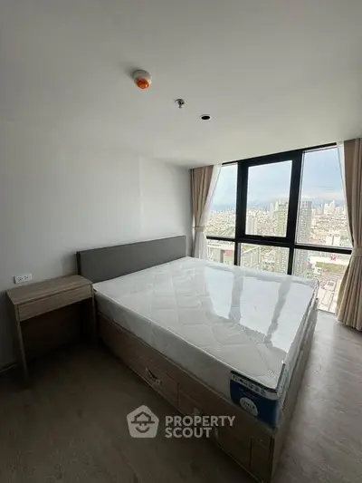 Modern bedroom with large window offering stunning city views