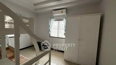 Cozy bedroom with bunk bed and wardrobe, featuring air conditioning and natural light.