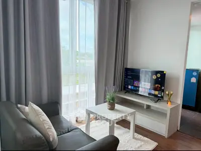 Modern living room with sleek furniture and large window offering natural light.
