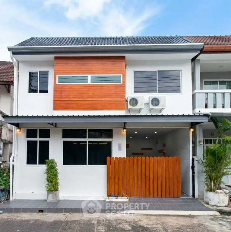 Modern two-story townhouse with sleek design and wooden accents in a vibrant neighborhood.