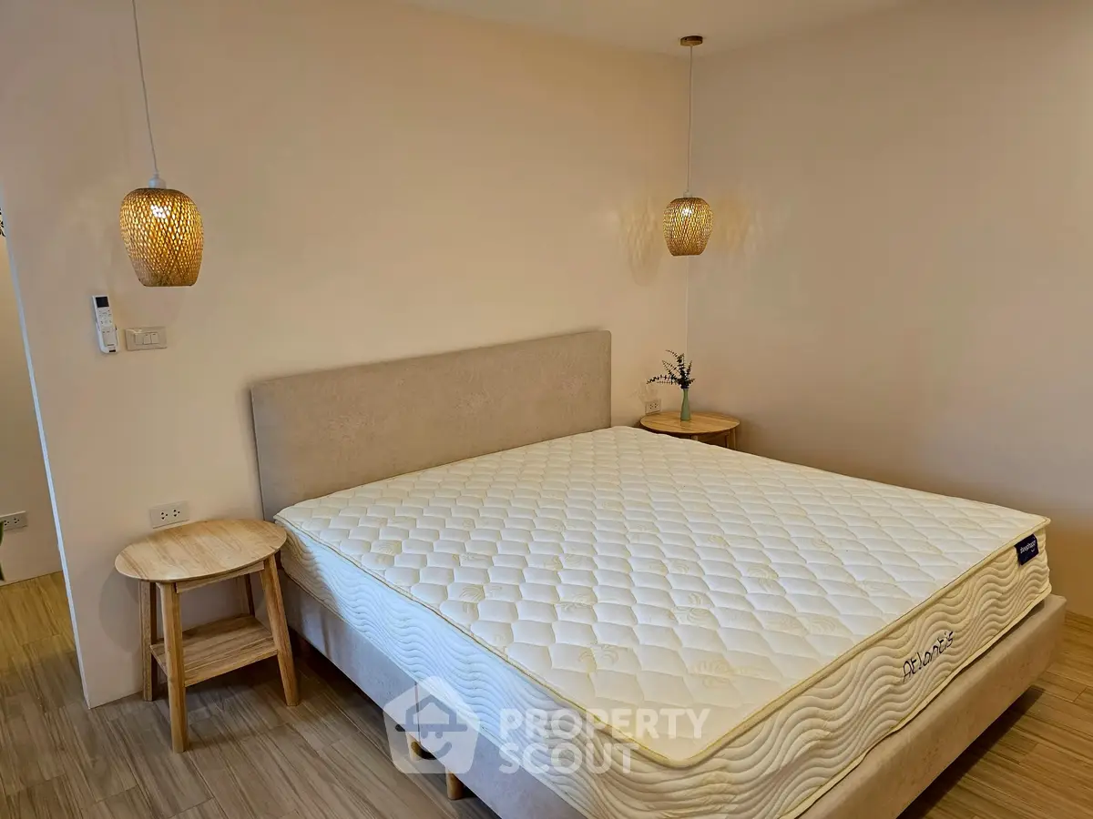 Cozy bedroom with stylish lighting and comfortable bed in modern apartment.