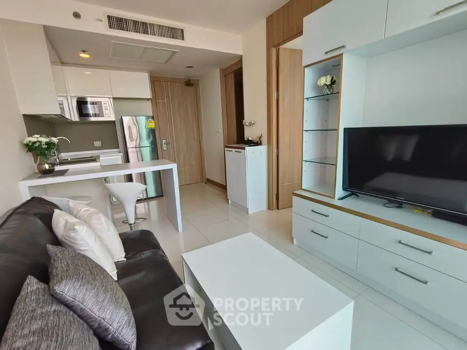 Modern living room with sleek furniture and open kitchen layout in a stylish apartment.