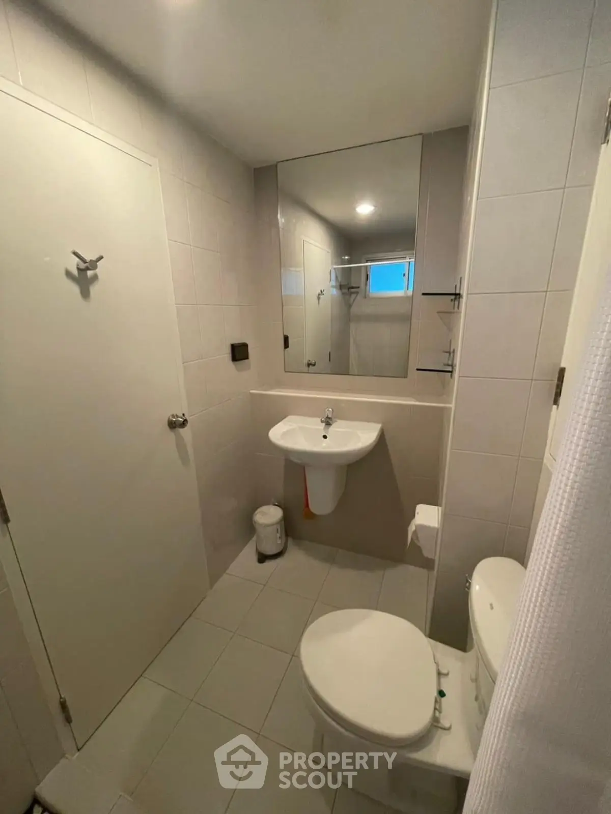Modern bathroom with sleek fixtures and large mirror in a contemporary apartment.