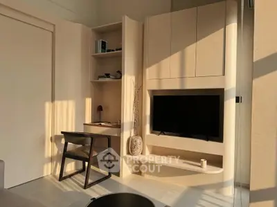 Modern living room with built-in TV unit and study nook, featuring sleek furniture and warm lighting.