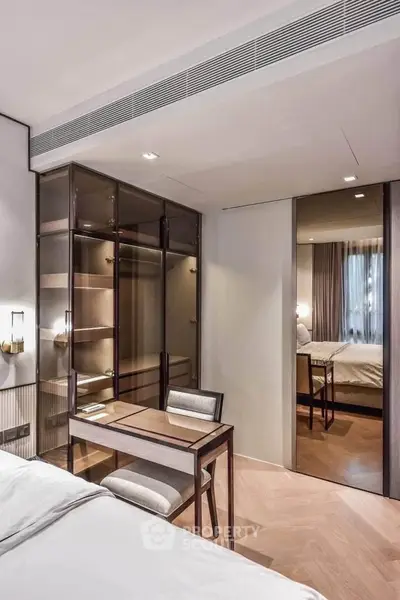 Luxurious bedroom with elegant furniture and modern design, featuring a stylish desk and large mirror.