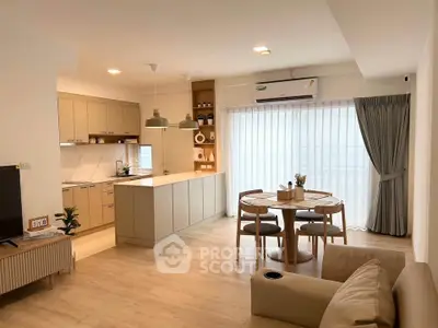 Modern open-layout kitchen and dining area with natural light and stylish decor.