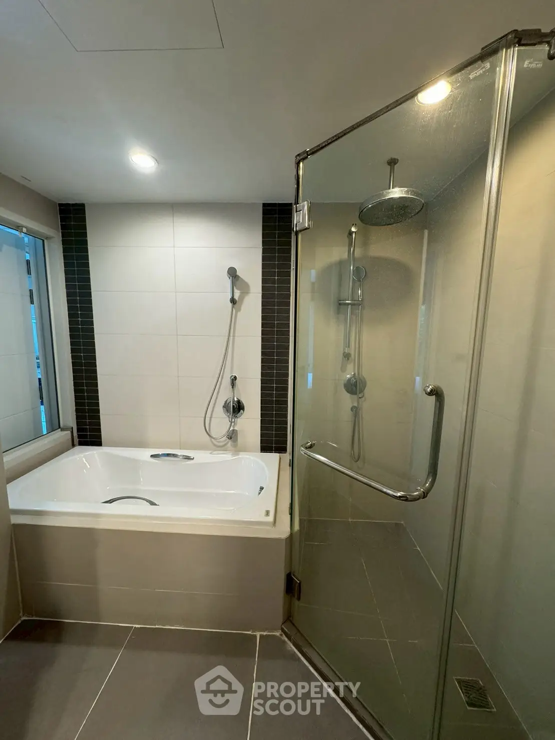 Modern bathroom with glass shower and built-in bathtub, sleek tiles and contemporary fixtures.
