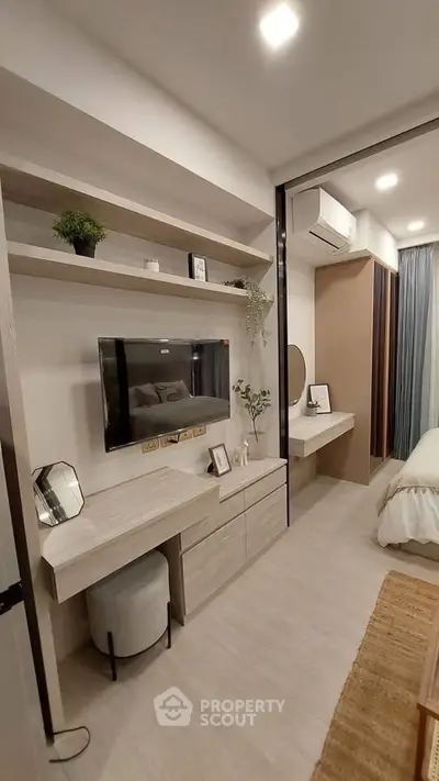 Modern bedroom with built-in desk, TV, and stylish decor in a cozy apartment.