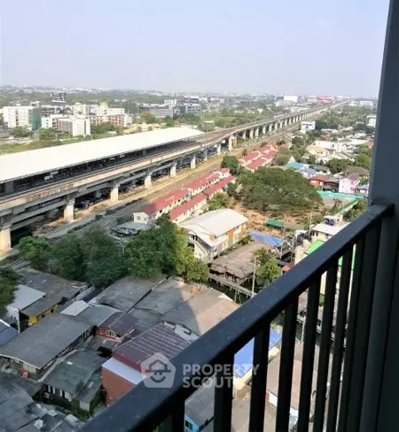Stunning cityscape view from high-rise balcony overlooking urban landscape and railway.