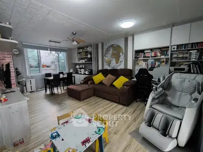 Spacious living room with modern decor and massage chair, ideal for family gatherings.