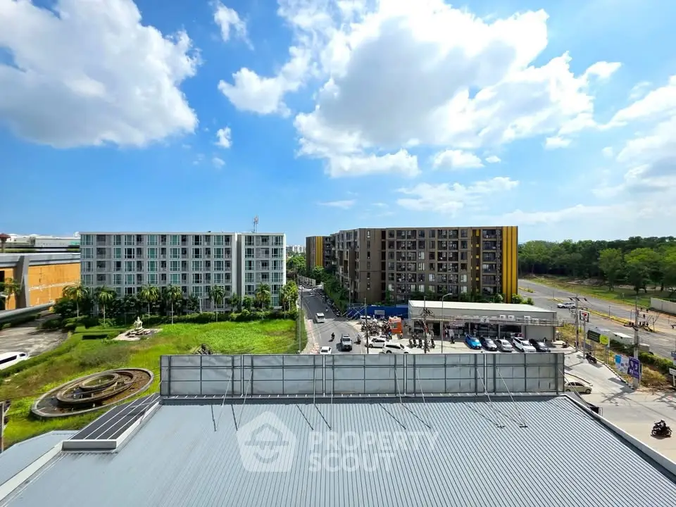 Stunning urban view with modern buildings and lush greenery under a bright blue sky.