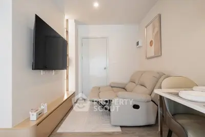 Modern living room with sleek TV setup and cozy recliner sofa