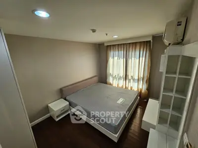 Modern bedroom with large window, hardwood floors, and minimalist furniture.