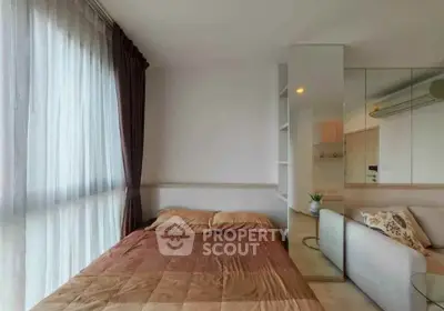 Cozy bedroom with large window and modern decor in a stylish apartment.