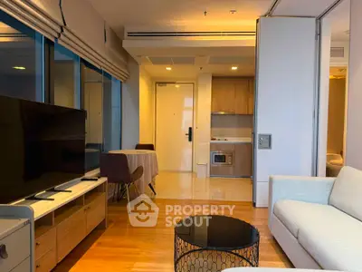 Modern living room with sleek furniture and open kitchen layout in a stylish apartment.