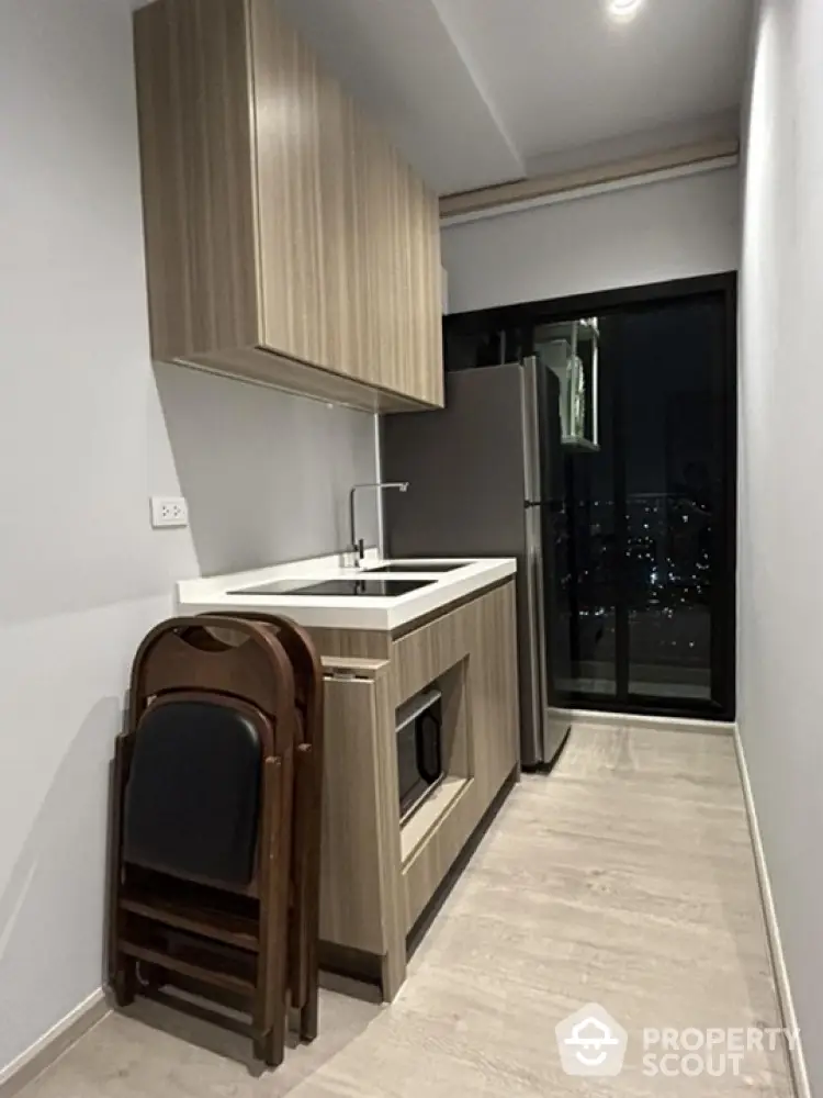 Modern kitchen with sleek cabinetry and city view from window