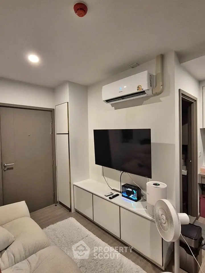 Modern living room with sleek TV setup and air conditioning unit.