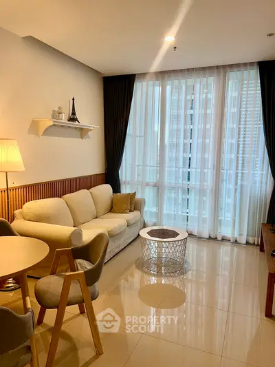 Modern living room with elegant decor and large windows offering city views.