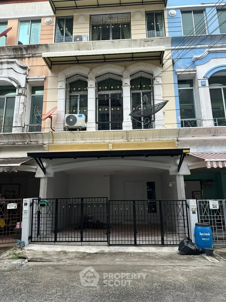 Charming townhouse exterior with gated parking in vibrant neighborhood