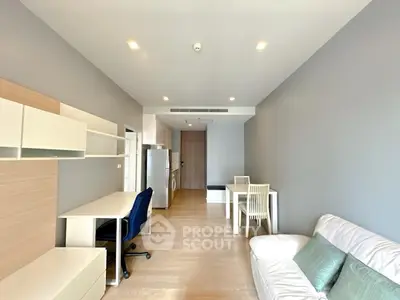 Modern living room with sleek furniture and open layout, featuring a cozy workspace and dining area.