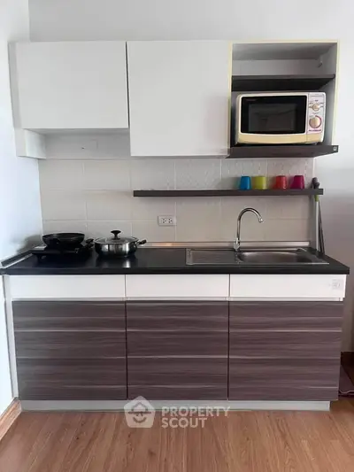 Modern kitchen with sleek cabinetry and built-in microwave, perfect for urban living.
