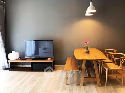 Modern living room with stylish wooden furniture and flat-screen TV, perfect for cozy gatherings.