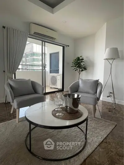 Modern living room with elegant decor and balcony access in a stylish apartment.