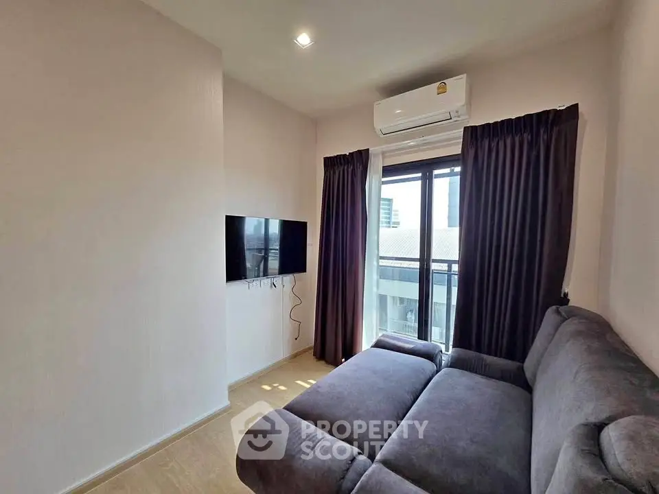 Cozy living room with modern sofa and wall-mounted TV, featuring a large window with city view.