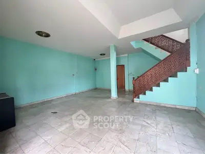 Spacious interior with unique staircase and tiled flooring, ideal for customization.
