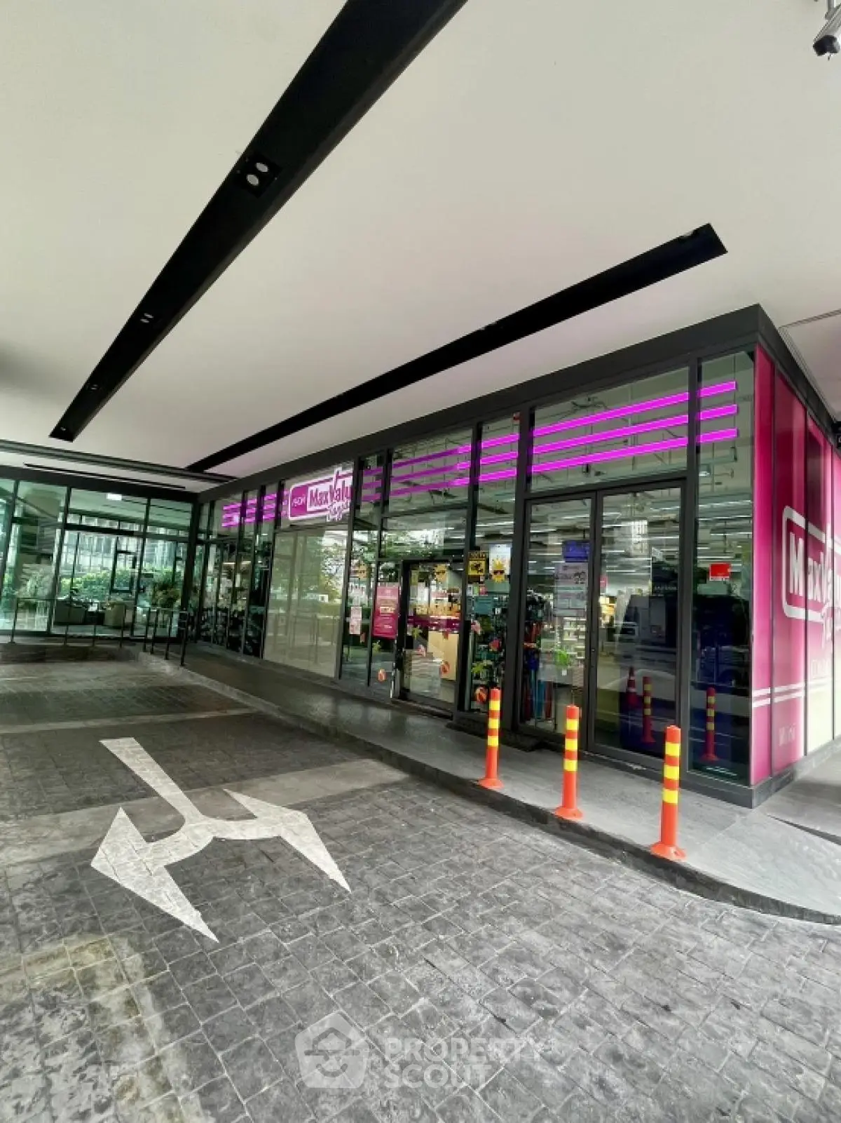Modern commercial building entrance with glass facade and vibrant signage