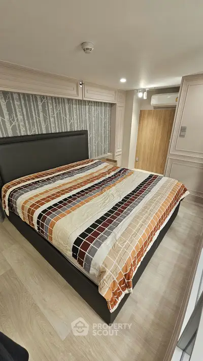 Spacious bedroom with modern decor and stylish bedding in a contemporary apartment.