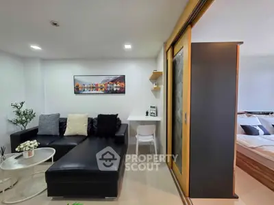 Modern living room with sleek black sofa and cozy decor