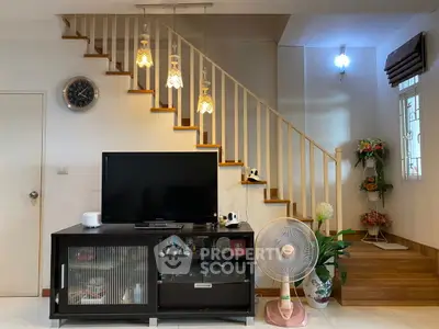 Charming living room with modern decor and stylish staircase, perfect for cozy family gatherings.