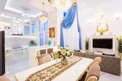Luxurious open-layout living and dining area with elegant decor and chandeliers