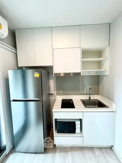 Modern compact kitchen with stainless steel fridge and built-in appliances