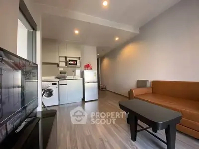 Modern living room with sleek kitchen appliances and cozy seating area