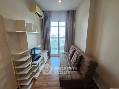 Cozy living room with modern sofa and entertainment unit, featuring large window with city view.