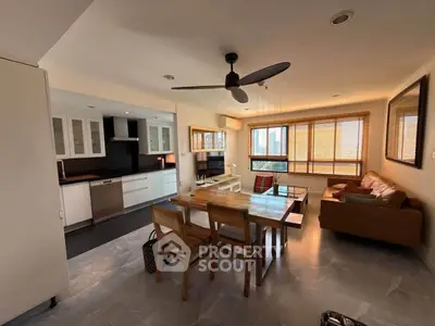 Spacious open-plan living room with modern kitchen and dining area, featuring natural light and stylish furnishings.